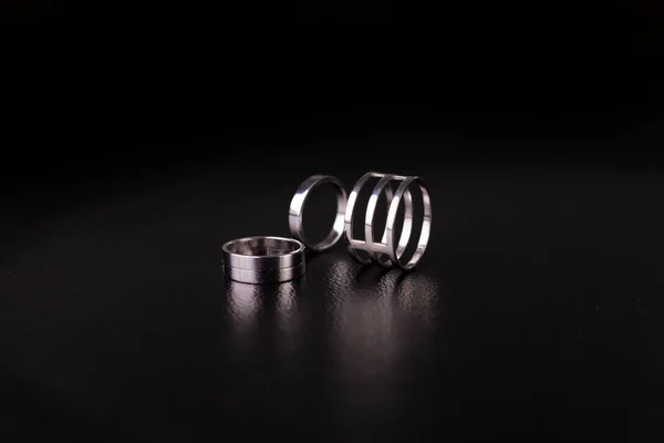 Fine silver jewelry on a black background with copy space