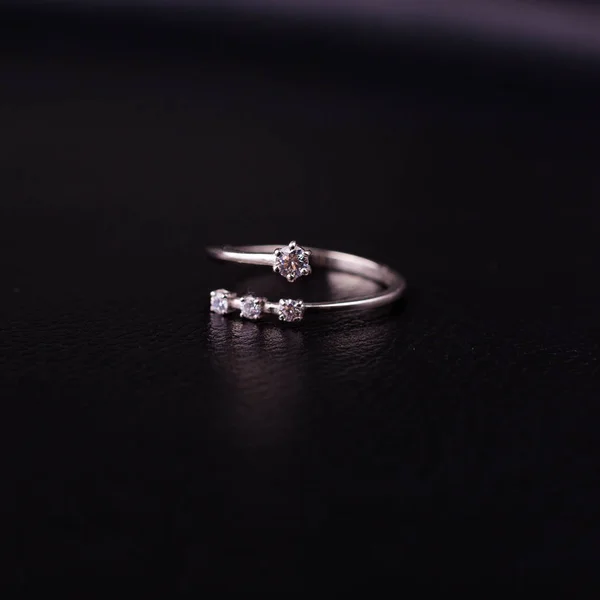 Fine silver jewelry on a black background with copy space