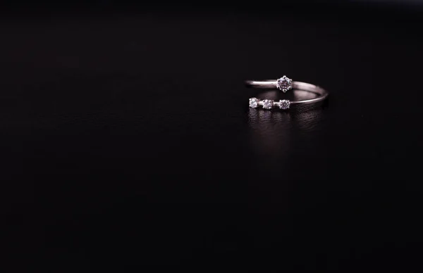 Fine silver jewelry on a black background with copy space