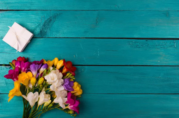 Ramo de flores de freesia sobre un fondo de madera — Foto de Stock