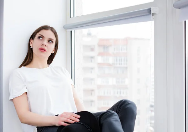 Hermosa mujer sentada junto a la ventana —  Fotos de Stock