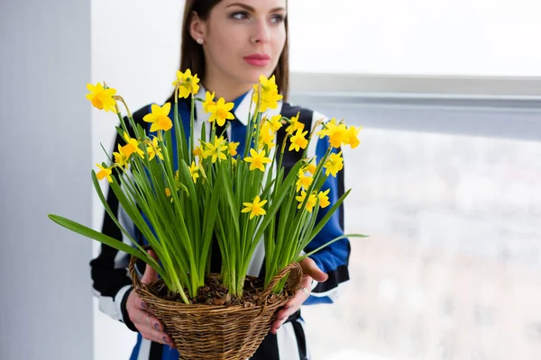 Beautiful woman with a flower basket full of Narcissus