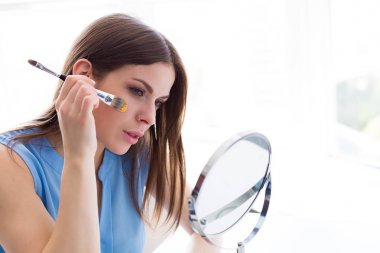 Kadının yüzündeki altın maske uygulamak