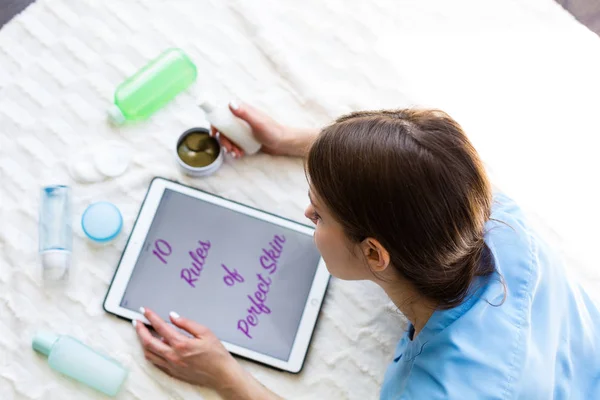 Woman reading an article about skincare — Stock Photo, Image