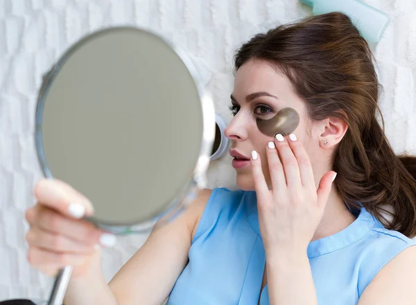Mulher aplicando adesivos para olhos de hidrogel — Fotografia de Stock