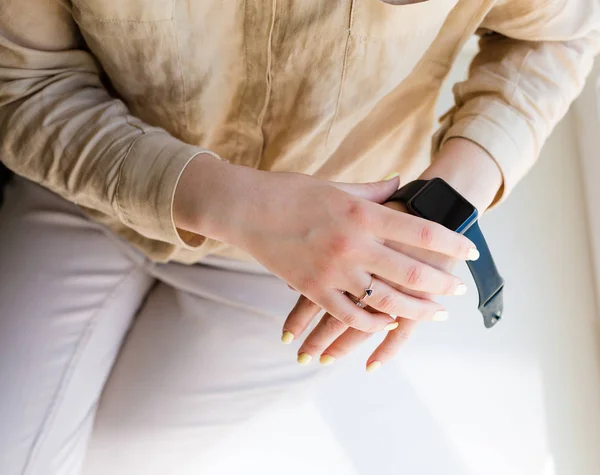 Mujer sosteniendo un reloj inteligente —  Fotos de Stock