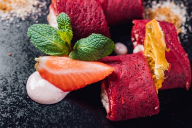 Pancar suyu ile krep, kırmızı krep. Tofu peyniri ile. Buğday unu, sebze sütü, mavi arka planda izole edilmiş, yakın plan, üst manzara.