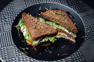 Ekmek, salatalık, yumurta beyazı, turp ve bezelye filizli vejetaryen sandviçi. Siyah arkaplanda izole edildi, kapat, üst görünüm