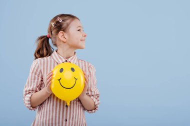 Çocuk, gülüşlü sarı balonlu kız. Yan tarafa bak.,