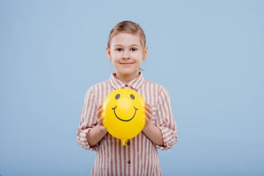 Gülümseyen sarı balonlu küçük kız. Kameraya bak.,