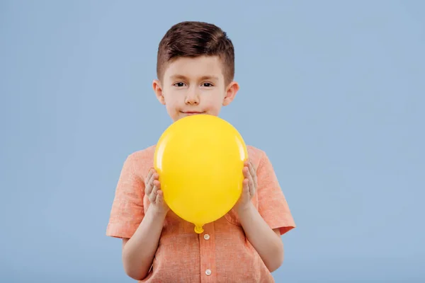 Mały chłopiec z żółtym balonem. patrzy w kamerę., — Zdjęcie stockowe