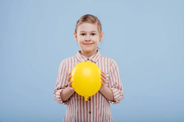 Menina com balão amarelo. olha para a câmera , — Fotografia de Stock