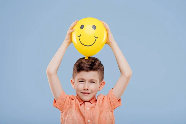 Menino segura o balão amarelo com sorriso . — Fotografia de Stock