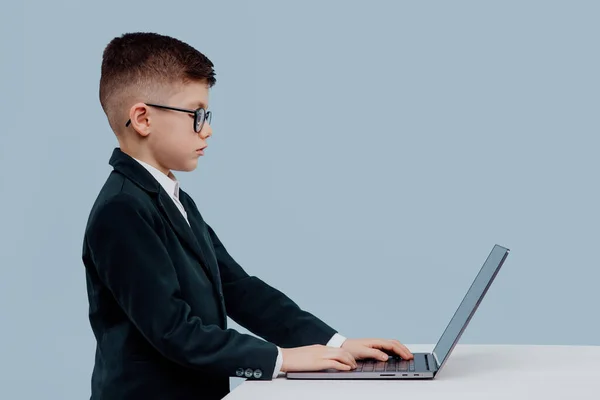 Yandan bakan okul çocuğu. bir dizüstü bilgisayar kullanarak gözlük — Stok fotoğraf
