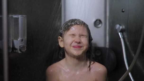 Niño lava su cabeza bajo un chorro de agua tibia — Vídeo de stock