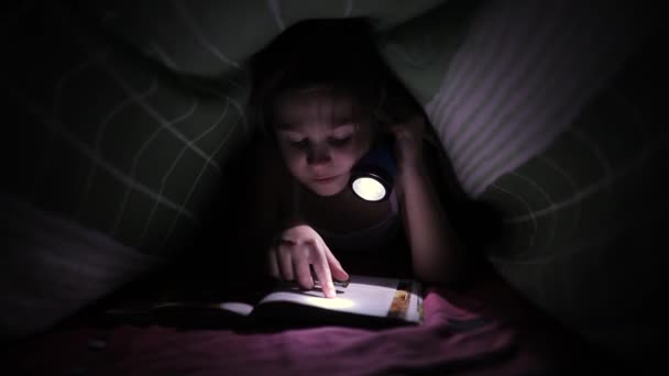 Bambina che legge un libro con una torcia elettrica — Video Stock