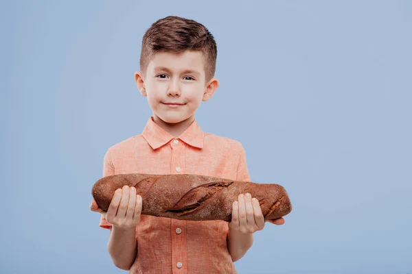 Niño sosteniendo un pan, mira a la cámara , —  Fotos de Stock