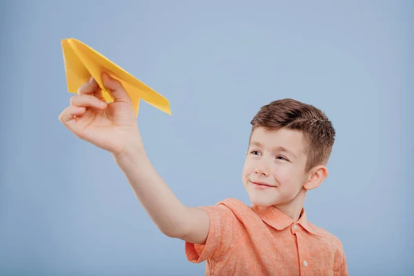 Child boy plays with yellow paper plane, — Stock Photo, Image