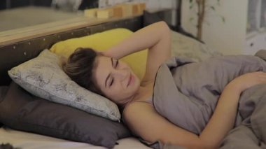 Genç ve güzel bir kadın sağlıklı bir uykudan sonra uyanır.