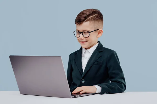Счастливый маленький бизнес-мальчик в очках с ноутбуком , — стоковое фото