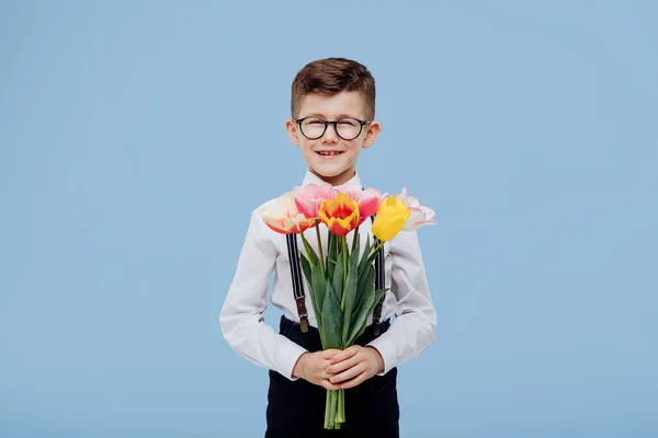 Niño sonriente niño con gafas mano flores —  Fotos de Stock