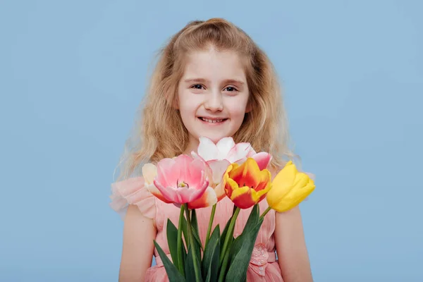 Enfant fille en robe rose avec des fleurs de printemps à la main — Photo