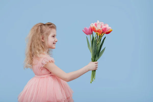 Little girl in pink dress with spring flowers in hand — Stock Photo, Image