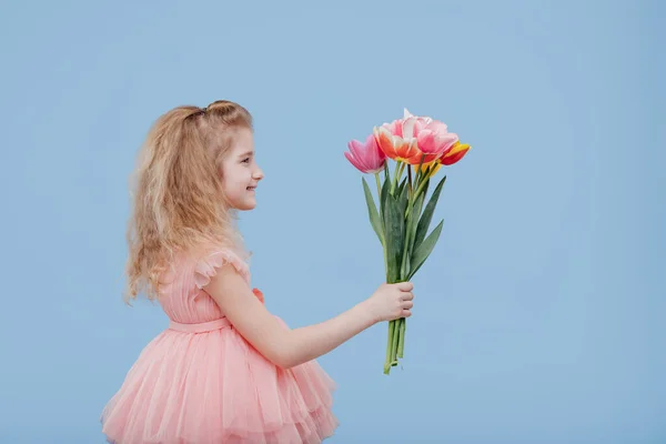 穿着粉色衣服，手里拿着春花的小女孩 — 图库照片