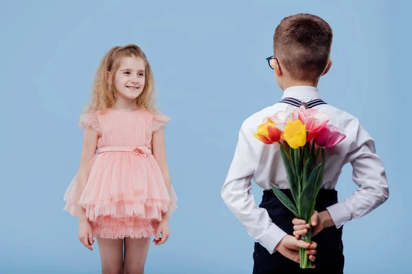 Back view, two little child boy with flowers and girl in pink dres — Stock Photo, Image