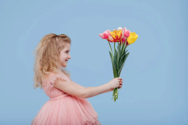 Little girl in pink dress with spring flowers in hand — Stock Photo, Image