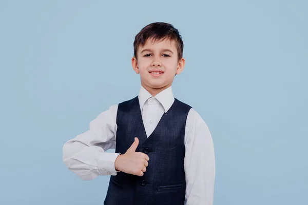 Happy little kid in shirt and vest pointing with finger — Stock Photo, Image