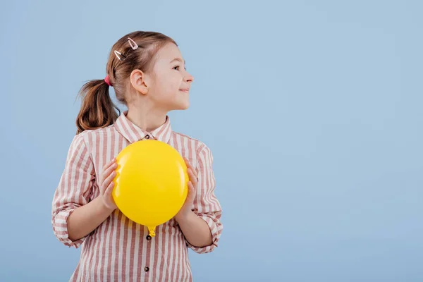 Criança, menina com balão amarelo olhar para o lado , — Fotografia de Stock