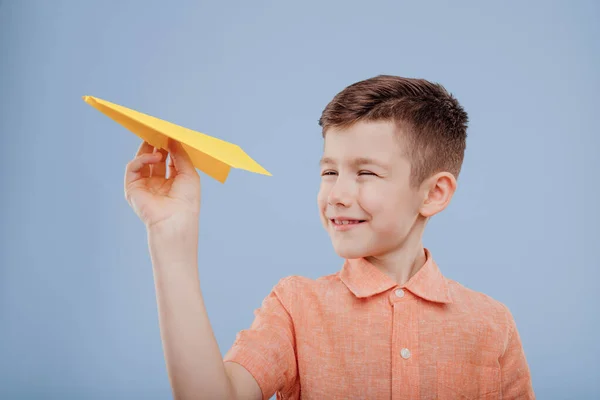 Menino brinca com avião de papel amarelo , — Fotografia de Stock