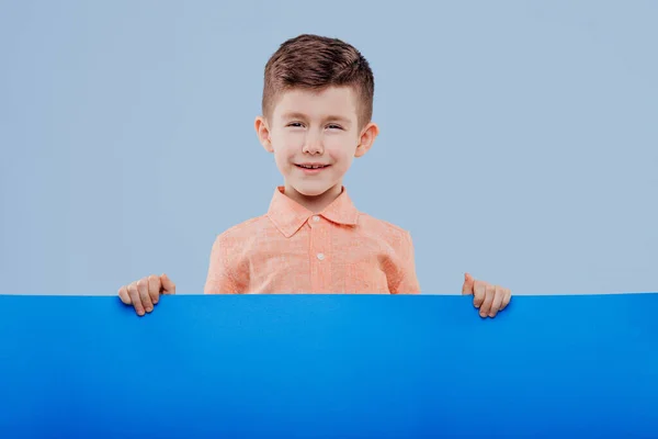 Feliz sonrisa hermoso niño mostrando letrero en blanco —  Fotos de Stock