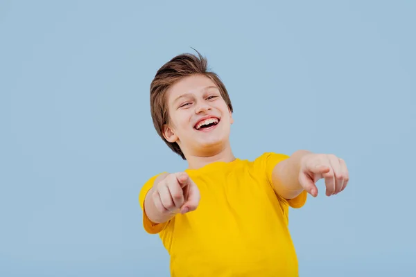 Ironiquement garçon pointant vers la caméra, en t-shirt jaune — Photo