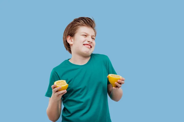 Pojke äter en citron, sur smak, göra grimace, — Stockfoto