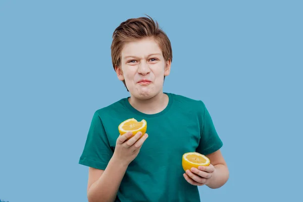 Preteen garçon goût un citron frais, goût aigre — Photo