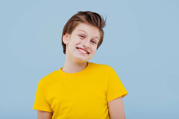 Jeune garçon souriant regarde la caméra, en t-shirt jaune — Photo