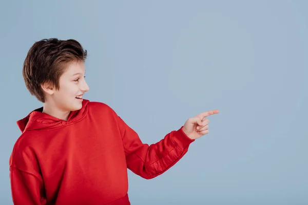 Happy boy pointing with finger in side direction — Stock Photo, Image