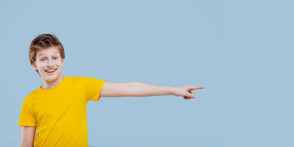 Happy surprised boy gesturing in studio on blue background — Stockfoto