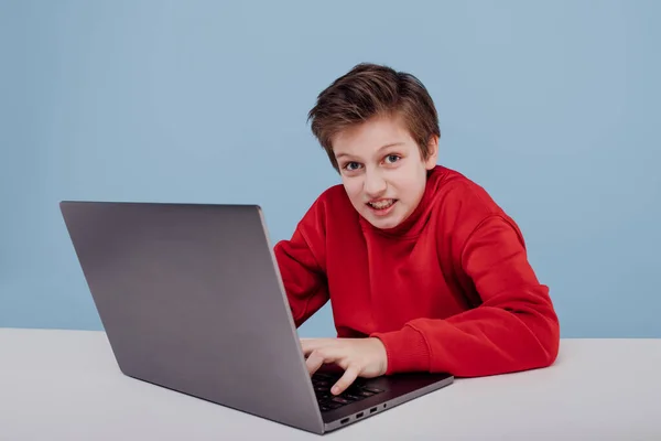 Мальчик рядом со столом с ноутбуком — стоковое фото