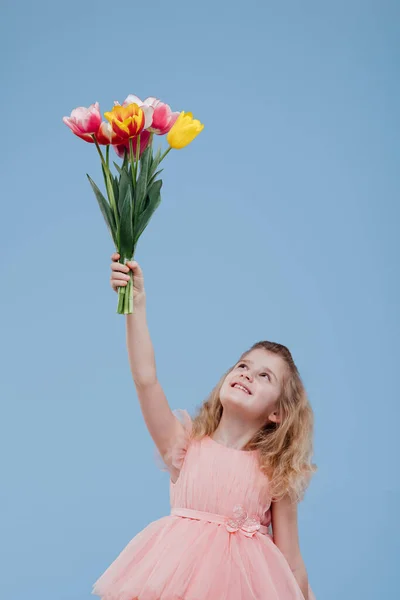Happy girl raising hands with bouquet of flowers — Stock Photo, Image