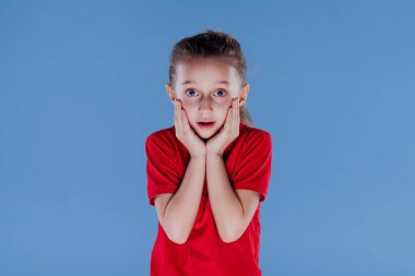 Şaşkın küçük kız kameraya bakıyor.