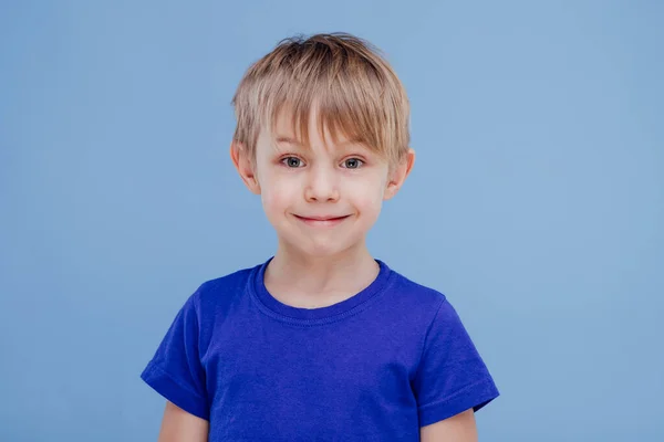 Menino bonito olha para a câmera vestida de camiseta azul , — Fotografia de Stock