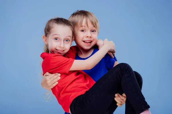 Joyeux petit garçon tenant positive soeur souriante sur les mains — Photo