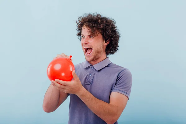 Aufgeregter Mann mit aufgeblasenem Ballon im Studio — Stockfoto