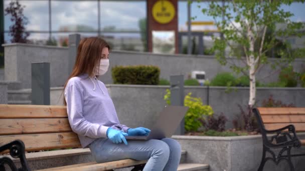 Young girl wearing medical gloves and face mask communicating by video — Stock Video