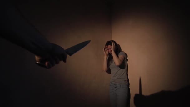 Rädd ung kvinna står i hörnet attackeras med en kniv, — Stockvideo
