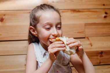 Mutlu küçük kız vejetaryen buzdağını yiyor.