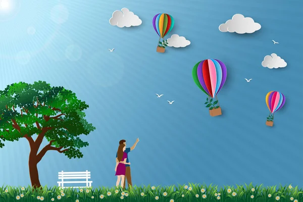 Conceito de eco friendly salvar a conservação do meio ambiente, casal de pé no prado e olhando para balão de ar quente voando com árvore — Vetor de Stock
